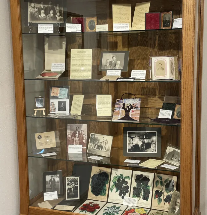 Museum display of photographs and letters inside a cabinet