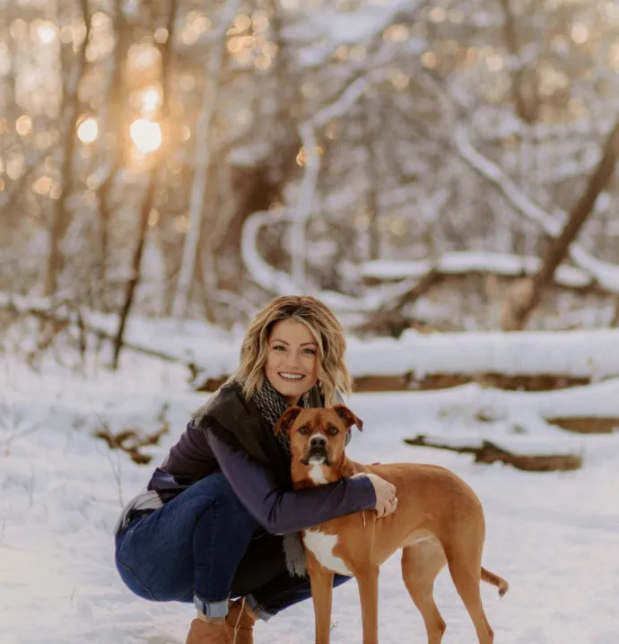 Riley Schreder and dog outside on snowy day