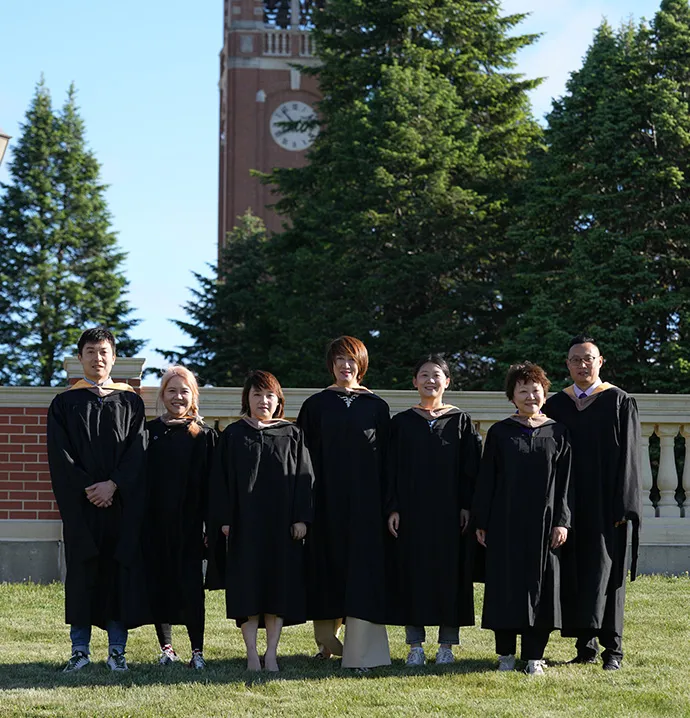 Shanghai MBA students stand in front of campanile. 