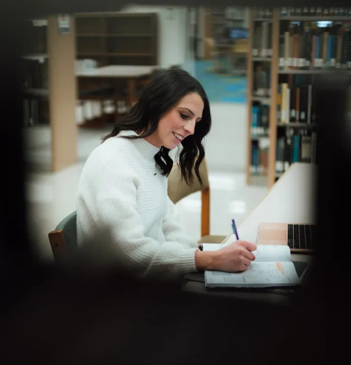 Student writing at the UNI Rod Library