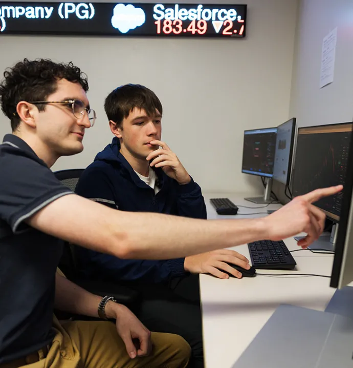 Students analyze stock market trends during an Investment Club meeting