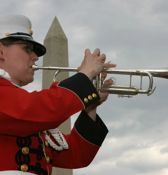 Susan Rider playing trumpet in front of the Washington Monument