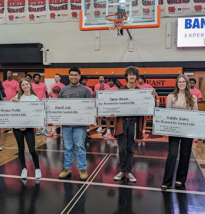 Scholarship recipients holding up big checks