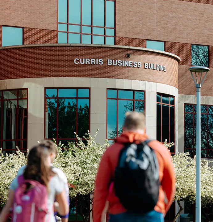 Students walking toward Curris Business Building
