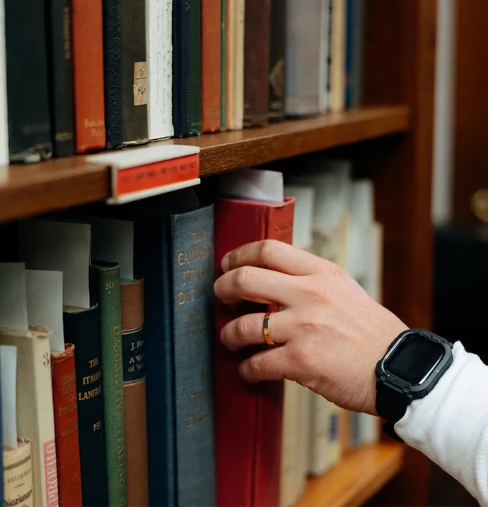Student doing undergraduate research grabbing book