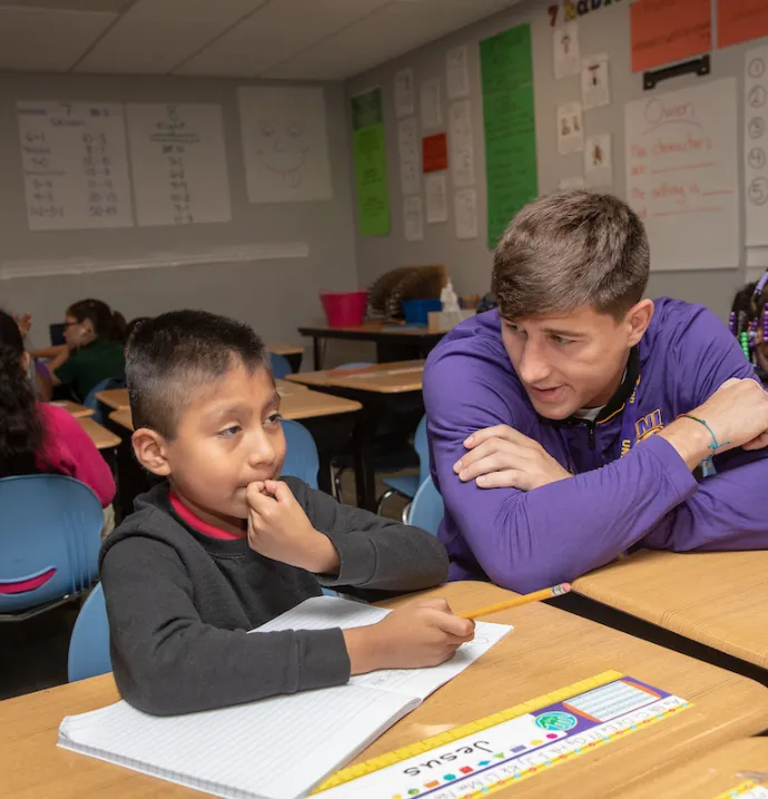 Teacher helps student in classroom
