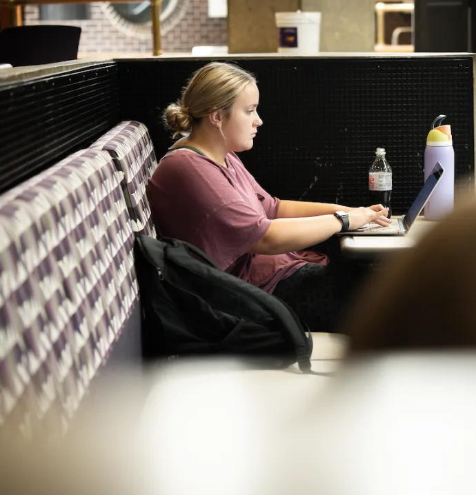 Student on laptop on University of Northern Iowa campus