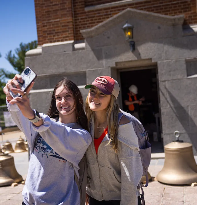 Students take a selfie in front of the carillon bells