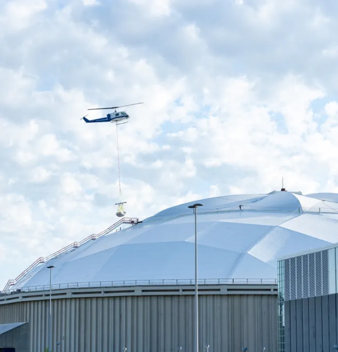 Helicopter lowering materials onto UNI-Dome