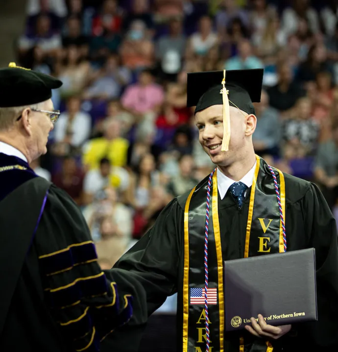 Graduate shaking President Nook's hand at Commencement