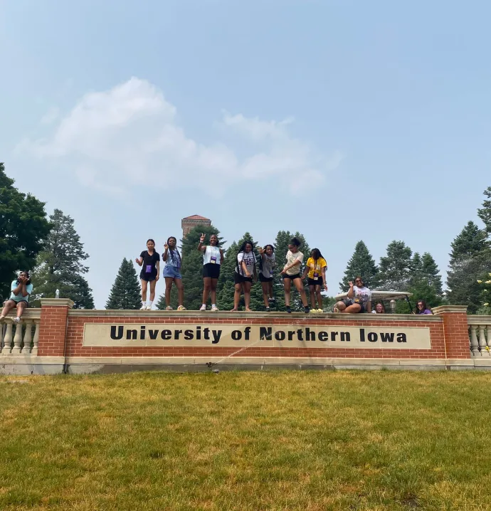 Upward Bound Math and Science students standing on University of Northern Iowa sign on campus