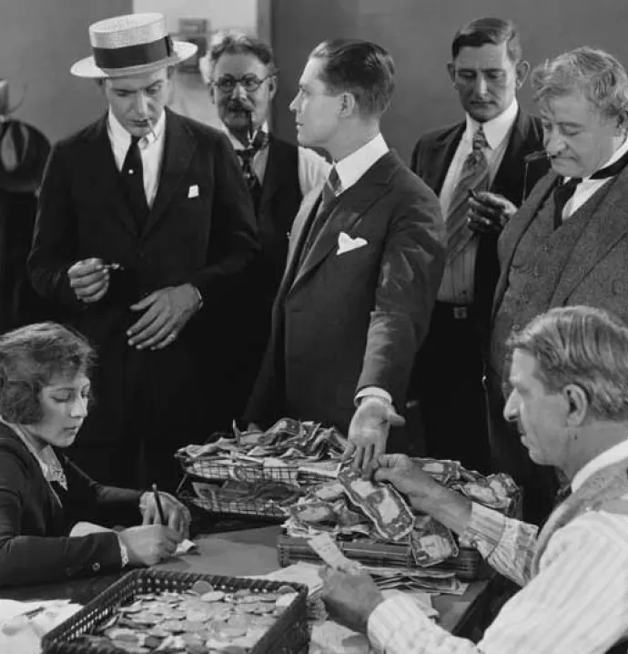 black and white photo of men counting money