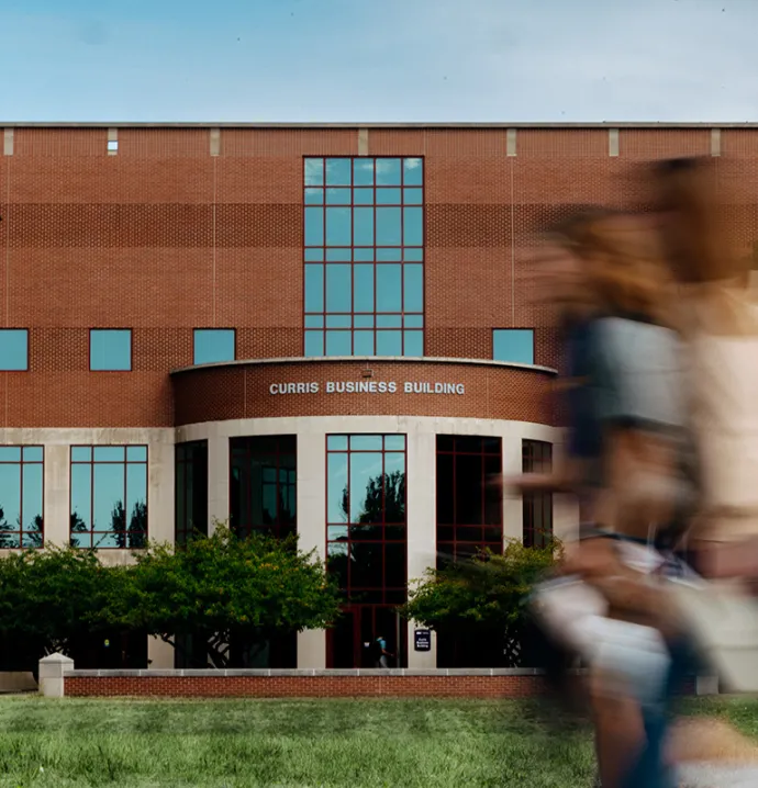 Students walk past Curris Business Building, where Wilson students turn internships into career confidence through hands-on learning and real-world business experiences.