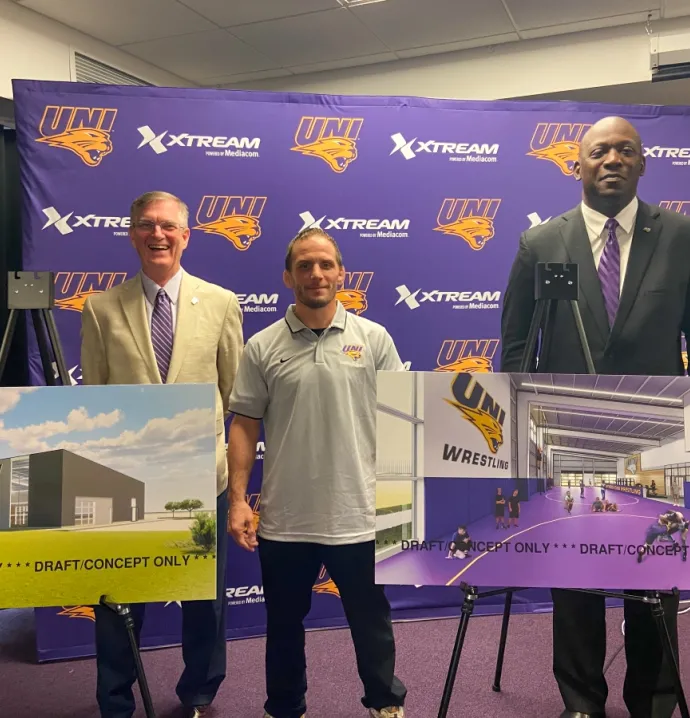 President Mark Nook, Coach Doug Schwab, and Athletics Director David Harris in front of conceptual renderings of a UNI wrestling training facility