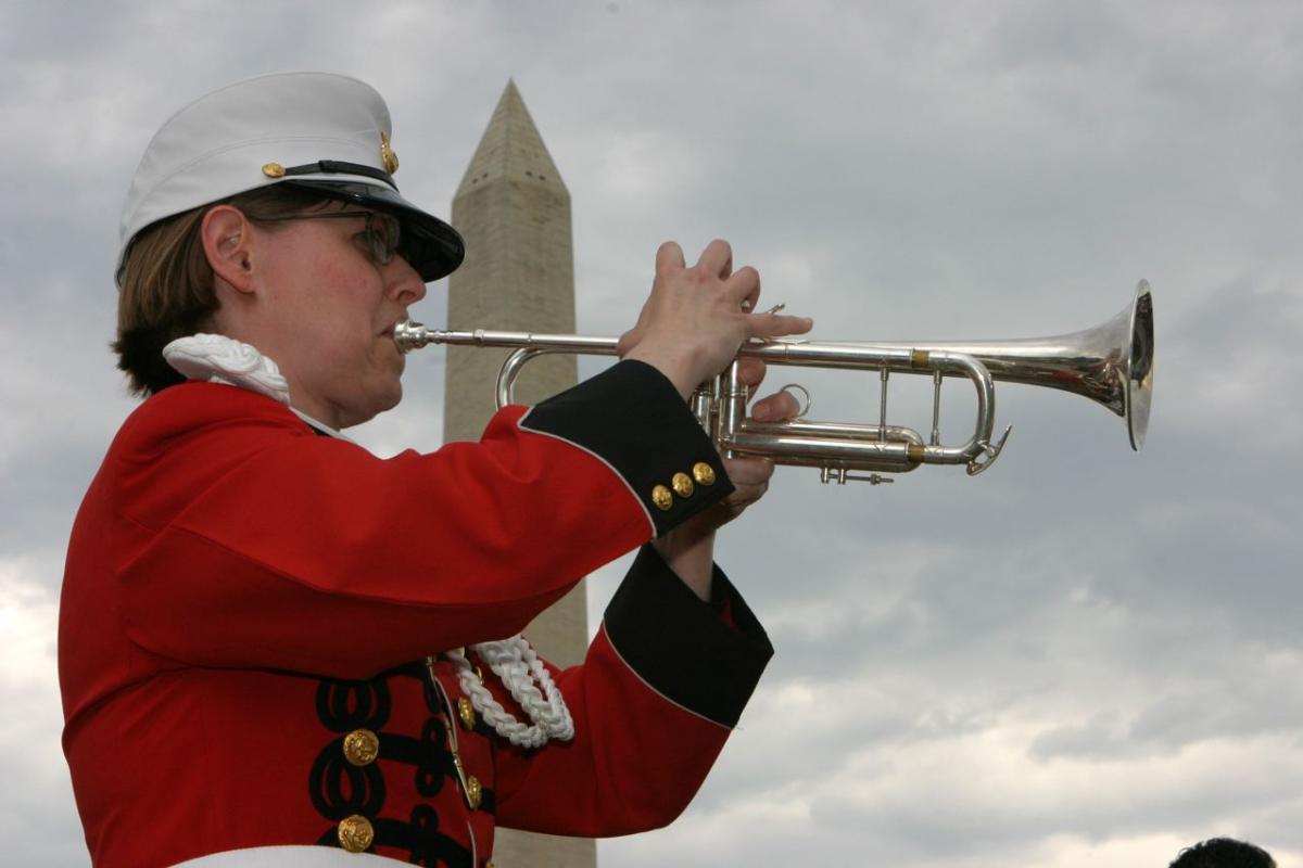 Susan Rider playing the trumpet in front of the Washington Monument