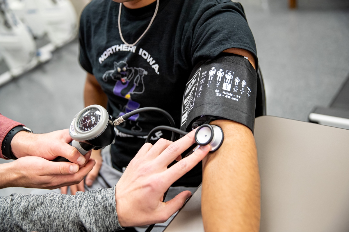 Student in blood pressure cuff