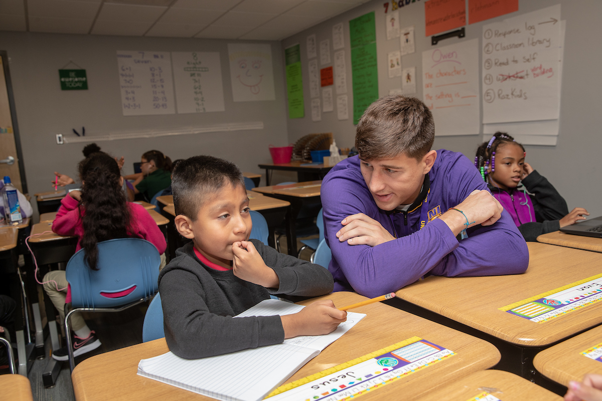 Teacher helps student in classroom