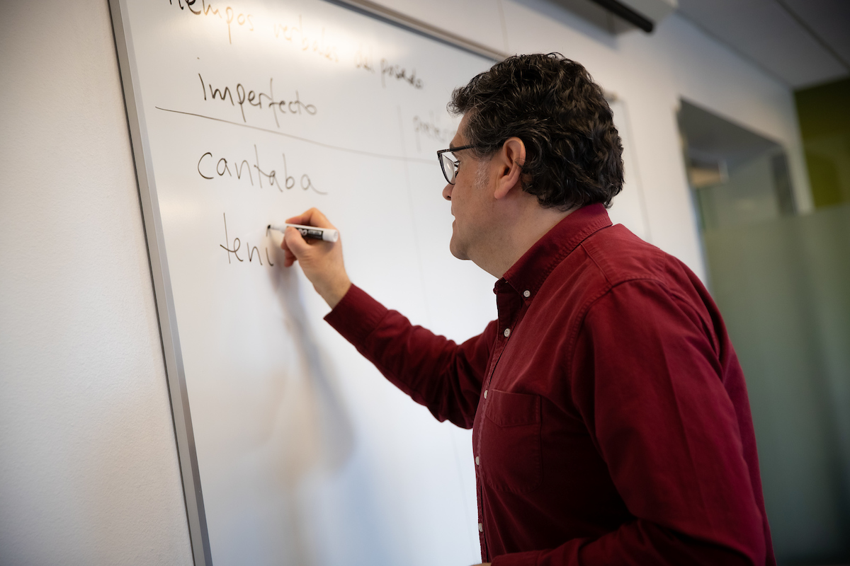 Juan Carlos Castillo writing in Spanish on white board