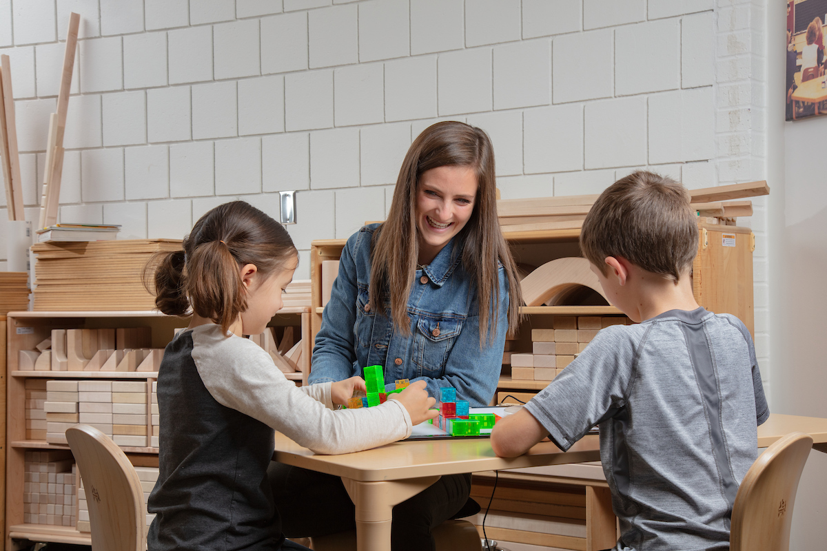 Students playing with blocks with their teacher 