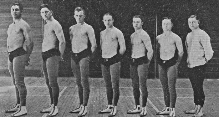 Seven wrestlers in black and white