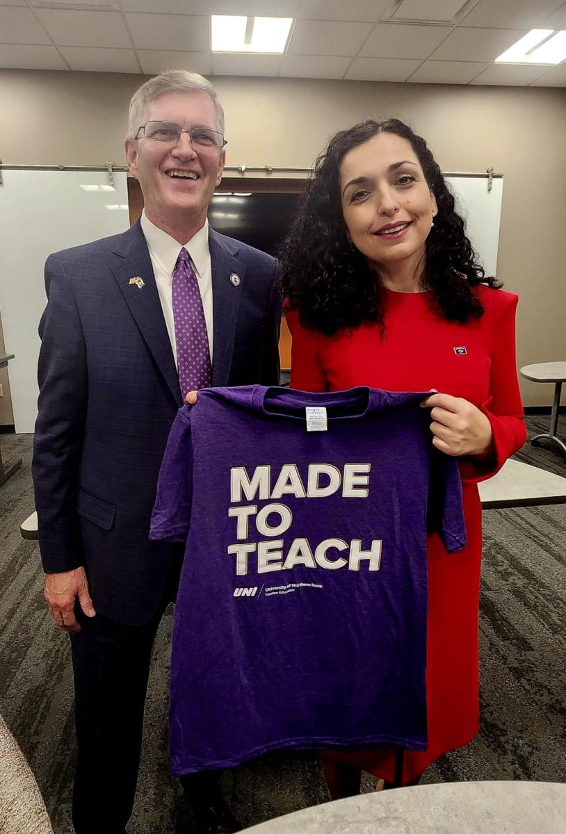 UNI president with president of Kosovo holding Made to Teach t-shirt