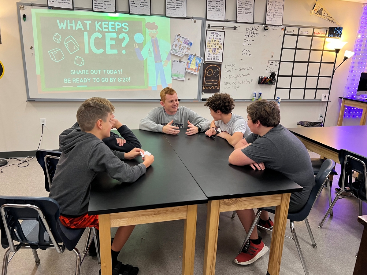 Zach Lillquist teaching students at a table in his classroom